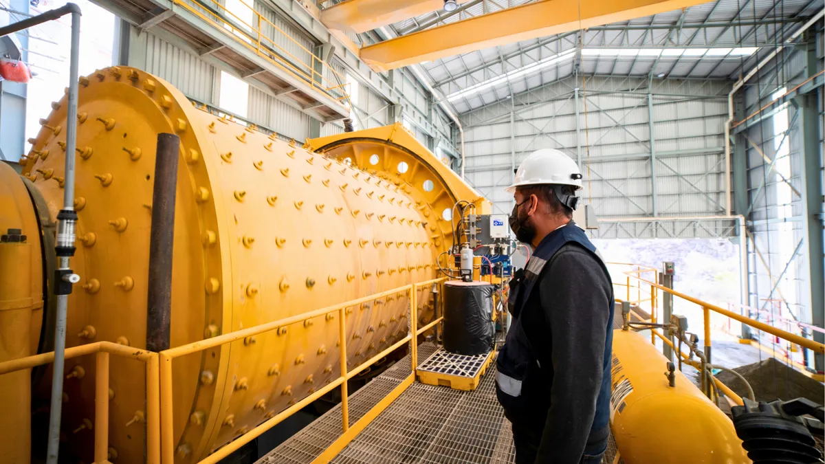 Technician inspecting industrial mill equipment before cleaning