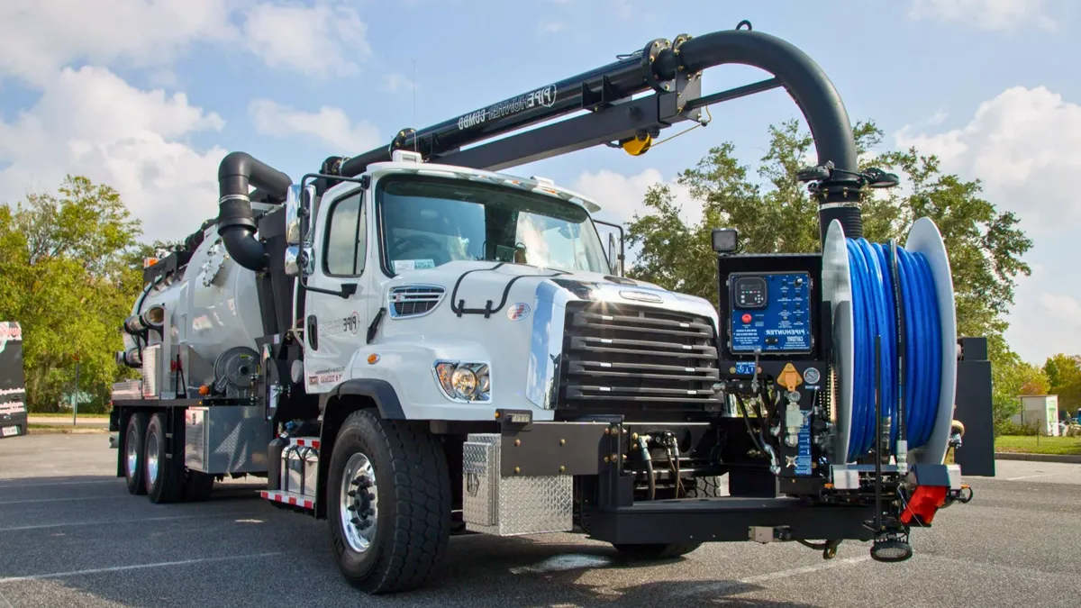 Industrial vacuum truck with boom and hose reel on site